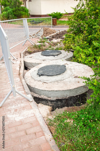 Construction site with concrete septic tanks and safety barriers