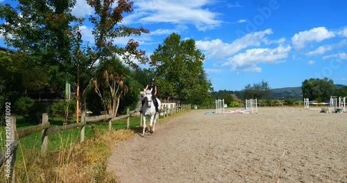Beautiful young female rider tgalopping on her horse in slow motion