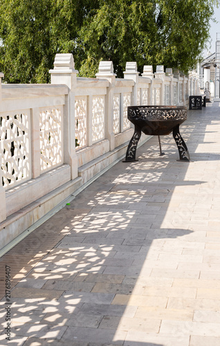 Obraz na płótnie White decorative marble railings along a sunlit path with a decorative metal bra