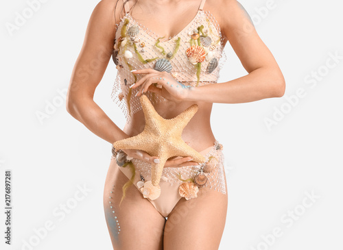 Bild auf Leinwand Beautiful young woman dressed as mythical mermaid with starfish on grey backgrou