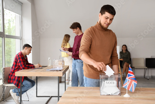 Photography Voting young man near ballot box with UK flag at polling station