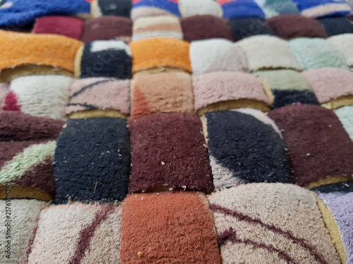 Obraz na plátně Colorful patchwork doormat made from assorted textured fabric pieces arranged in a geometric pattern, close up household floor mat background