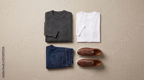 Flat lay of mens casual clothing and shoes arranged neatly on a neutral background.