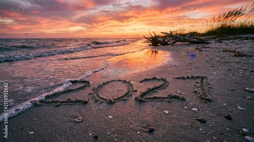 Inscribed 2027 in Wet Sand on Coastal Beach with Sunset Water Waves