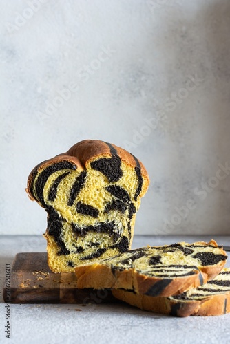  Pumpkin marbled (tiger print) bread with cuttlefish ink, braided on a light background. Useful home baking. Texture laid out from slices of bread.