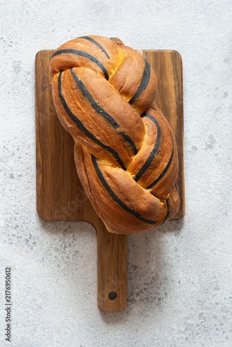  Pumpkin marbled (tiger print) bread with cuttlefish ink, braided on a light background. Useful home baking. Texture laid out from slices of bread.