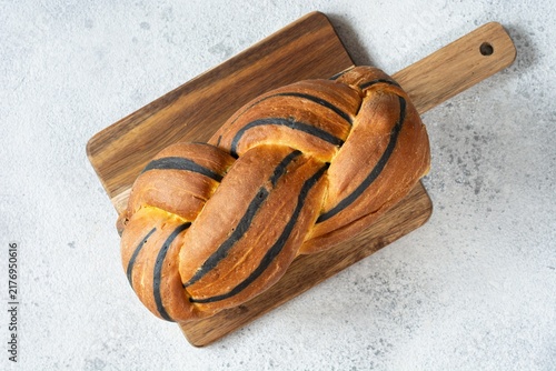  Pumpkin marbled (tiger print) bread with cuttlefish ink, braided on a light background. Useful home baking. Texture laid out from slices of bread.