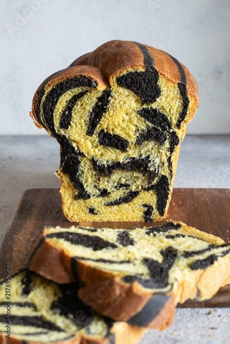  Pumpkin marbled (tiger print) bread with cuttlefish ink, braided on a light background. Useful home baking. Texture laid out from slices of bread.