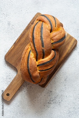  Pumpkin marbled (tiger print) bread with cuttlefish ink, braided on a light background. Useful home baking. Texture laid out from slices of bread.