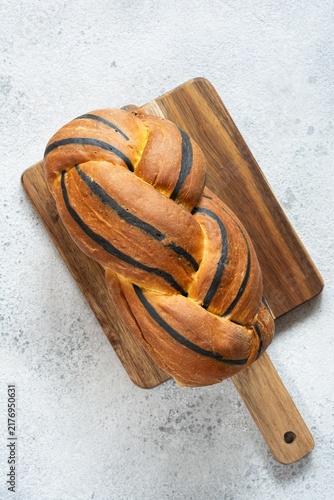  Pumpkin marbled (tiger print) bread with cuttlefish ink, braided on a light background. Useful home baking. Texture laid out from slices of bread.
