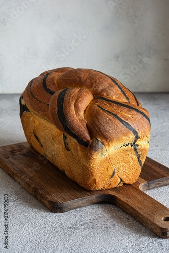  Pumpkin marbled (tiger print) bread with cuttlefish ink, braided on a light background. Useful home baking. Texture laid out from slices of bread.