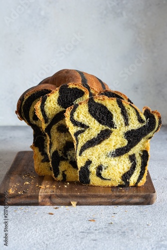  Pumpkin marbled (tiger print) bread with cuttlefish ink, braided on a light background. Useful home baking. Texture laid out from slices of bread.