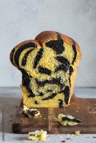  Pumpkin marbled (tiger print) bread with cuttlefish ink, braided on a light background. Useful home baking. Texture laid out from slices of bread.
