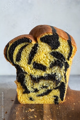  Pumpkin marbled (tiger print) bread with cuttlefish ink, braided on a light background. Useful home baking. Texture laid out from slices of bread.