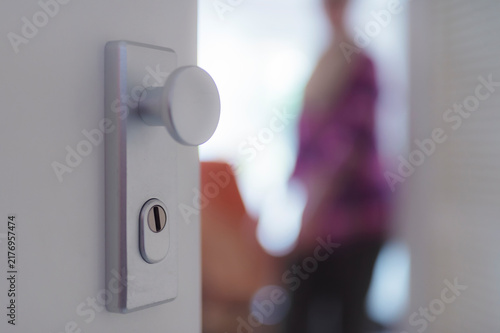 View through open apartment door to senior woman