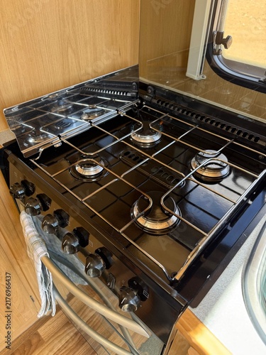 Cuadro en lienzo Gas stovetop burners with shiny grates and control knobs inside a compact carava