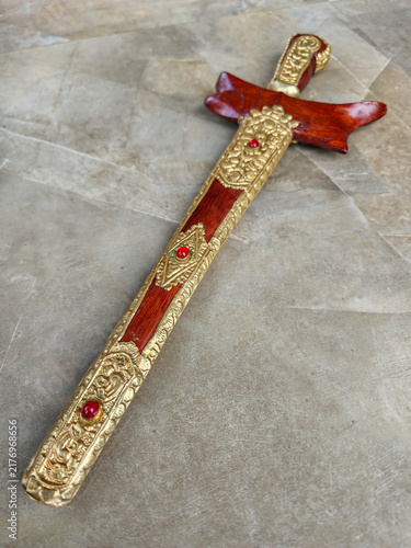 Fotografía Traditional Indonesian Wooden Kris Dagger Sheath with Golden Carvings and Red Ge
