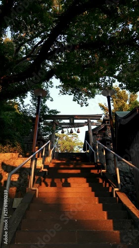 Slow Pan Down Shrine Stairs at Sunset Through Torii Gate in Japan