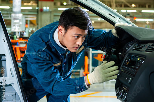 Konstfotografi Asian industrial workers are focused on installing interior parts for car dashboards