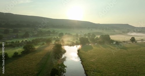 Sunrise over misty meadow and river in Yorkshire Dales