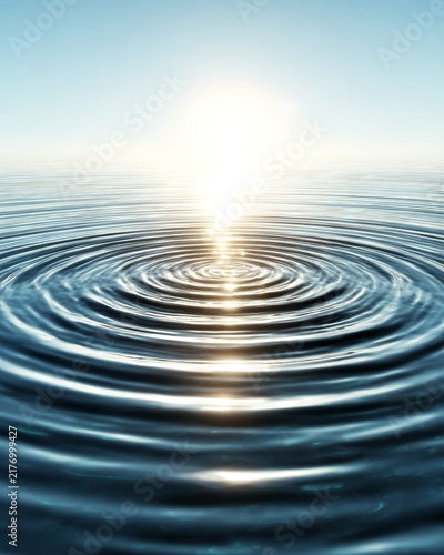 Serene water surface reflecting bright sunlight producing soft ripples against clear blue backdrop
