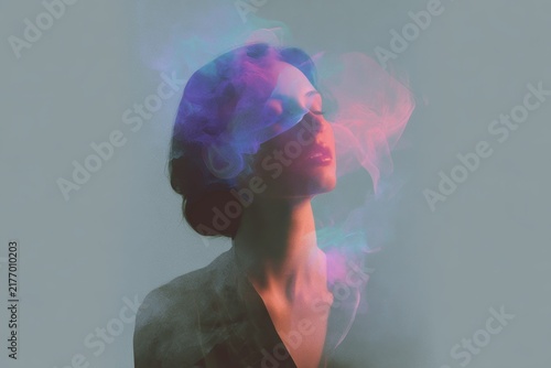 Portrait of woman with neon colored smoke and closed eyes for surreal background and poster design