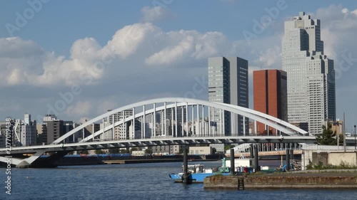 Fixed shot of Tsukiji Ohashi Bridge and a cluster of buildings in Chuo Ward, Tokyo.
