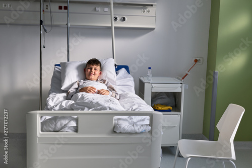 Konstfotografi Smiling child resting in a hospital bed during a calm afternoon in a pediatric w
