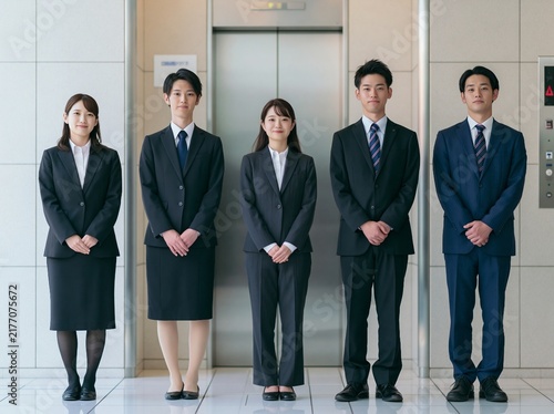 Plakat w ramie エレベーターホールの前で規律正しく整列するスーツ姿の男女