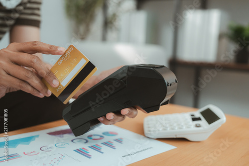 Obraz na płótnie Financial advisor using payment card and card reader for wealth planning