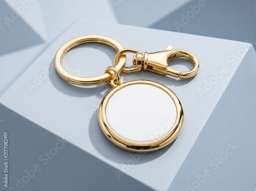 Elegant metallic gold keychain with a blank customizable round white insert, perfect for branding or personalization on a modern geometric display