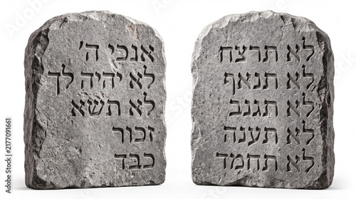 Ancient stone tablets featuring carved hebrew ten commandments standing upright in isolation on white background