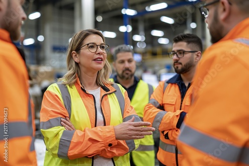 Female Manager Leading Team Meeting in Industrial Warehouse