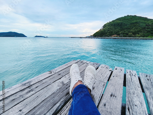 Selfie hipster wearing yellow sneaker shoes over summer beach background.