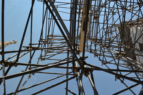 Metal scaffolding structure from below against blue sky for construction background and industrial pattern design