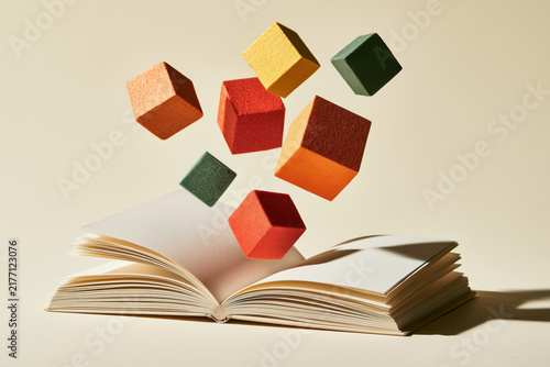 Colorful cubes float above an open book