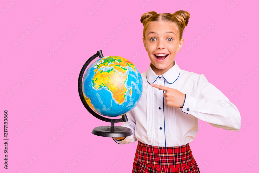 Fototapeta premium Portrait of her she nice attractive lovely cheerful cheery positive glad genius pre-teen girl in white shirt pointing at globe isolated over bright vivid shine yellow background