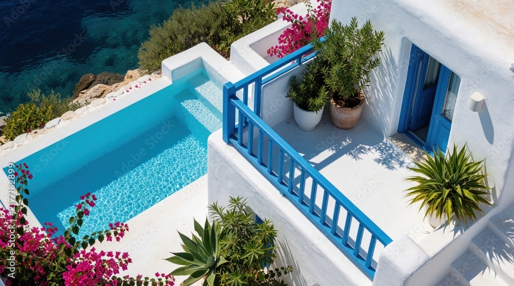 Obraz premium White villa with blue trim overlooks clear sea. Pool sits on sunlit cliffside terrace with rich potted plants. Bright Mediterranean vacation home invites relaxation by ocean.