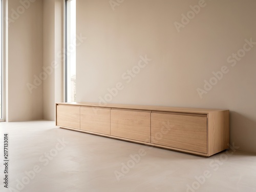 Low wooden sideboard against a neutral wall in a minimalist interior