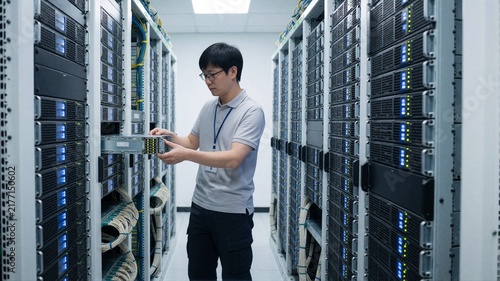 Naklejka IT Technician Installing Server Hardware in Data Center