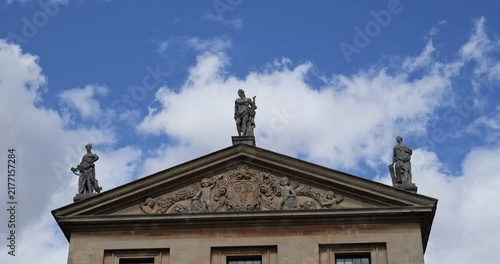 Oxford, Oxfordshire, United Kingdom, August 20, 2026. Statues adorn pediment top on classical university building roof facade.