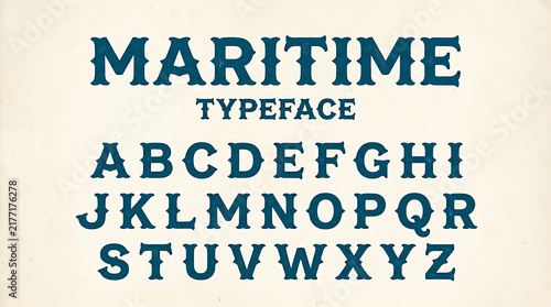 Vintage nautical serif alphabet display font with anchor style details on textured background