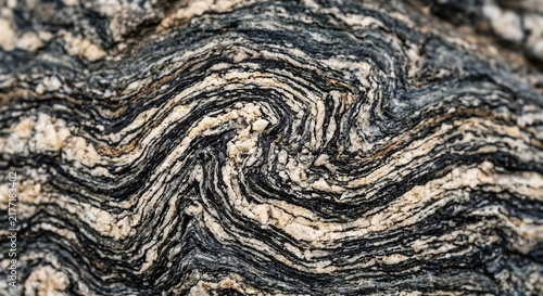 Wavy black and white banding texture of metamorphic gneiss rock