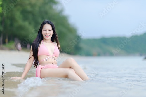 Joyful Woman in Pink Swimsuit Relaxing at Beach on Summer Day
