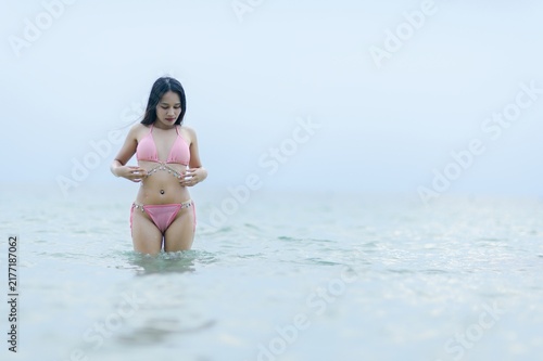 Woman in Pink Swimsuit Enjoying Summer at the Beach in Water
