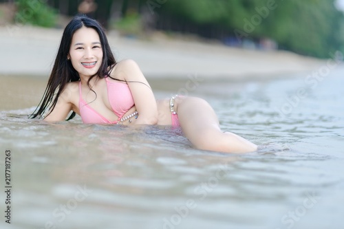 Woman in Pink Swimsuit Relaxing at the Beach on a Summer Day