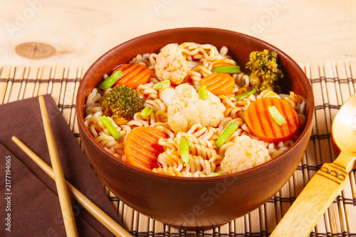 Udon stir-fry noodles with vegetables arranged on wooden surface.