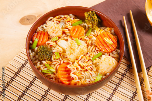 Asian vegetarian cuisine highlighted by udon noodles combined with broccoli and carrot.