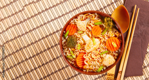 Veggie Noodles presented in clay bowl on bamboo background with copy space