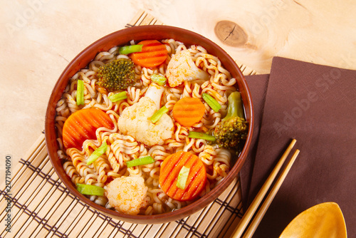 Noodles with vegetables served in clay bowl